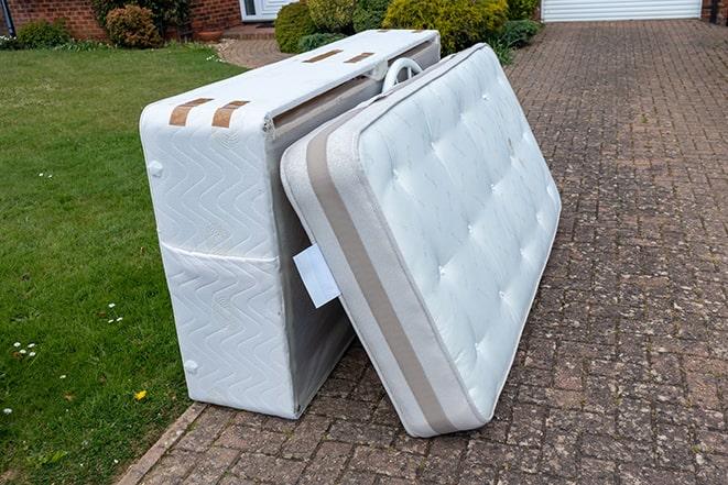 mattress being loaded onto a pickup truck for disposal